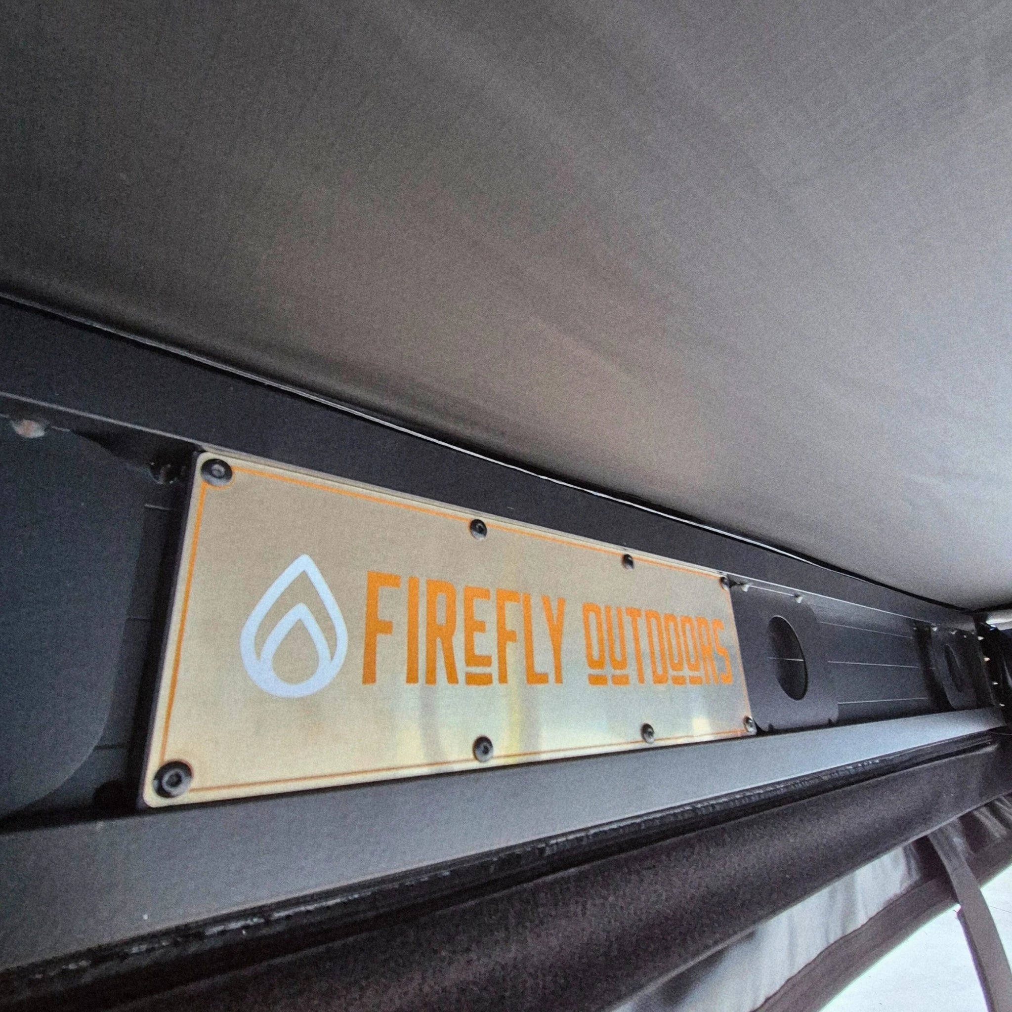 Firefly Outdoors logo plate on awning backing plate
