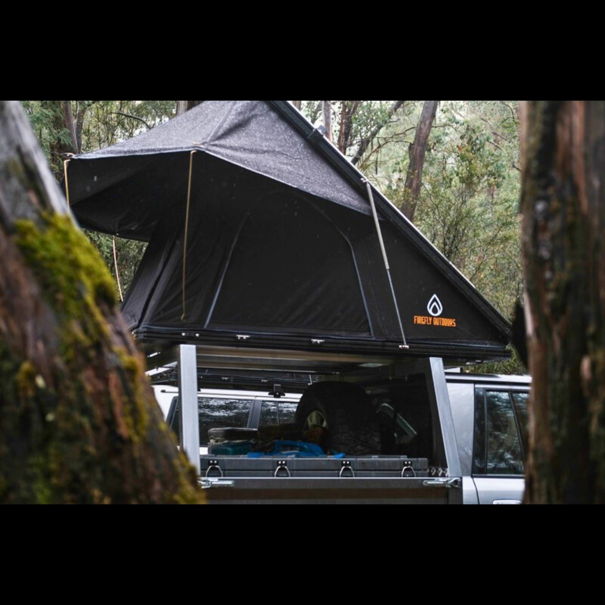 Firefly Outdoors - Phoenix 1.3 rooftop tent set up at off‑grid campsite with 4wd touring vehicle in forest 