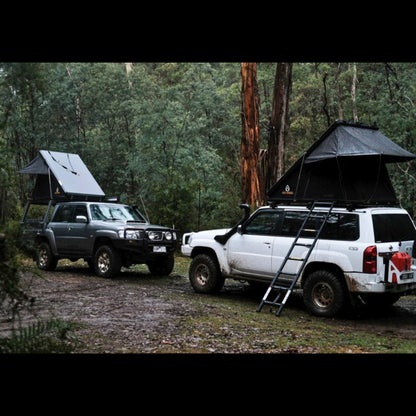 Firefly Outdoors - Phoenix 1.3 rooftop tent set up at off‑grid campsite with two 4wd touring vehicles in forest 