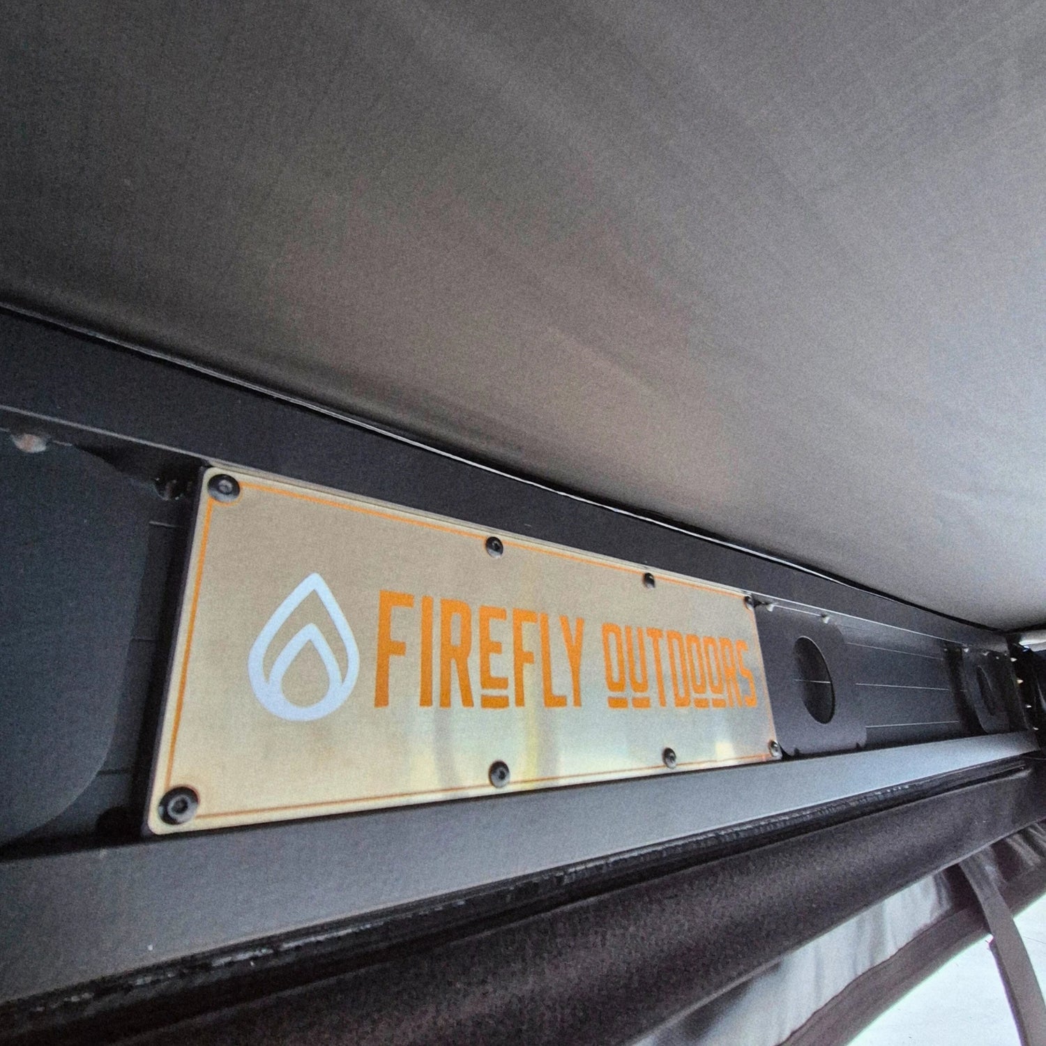 Firefly Outdoors logo plate on awning backing plate 